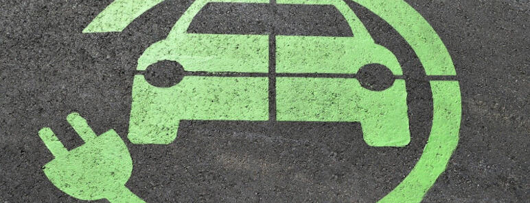 Aviso de zona de carga eléctrica en el asfalto